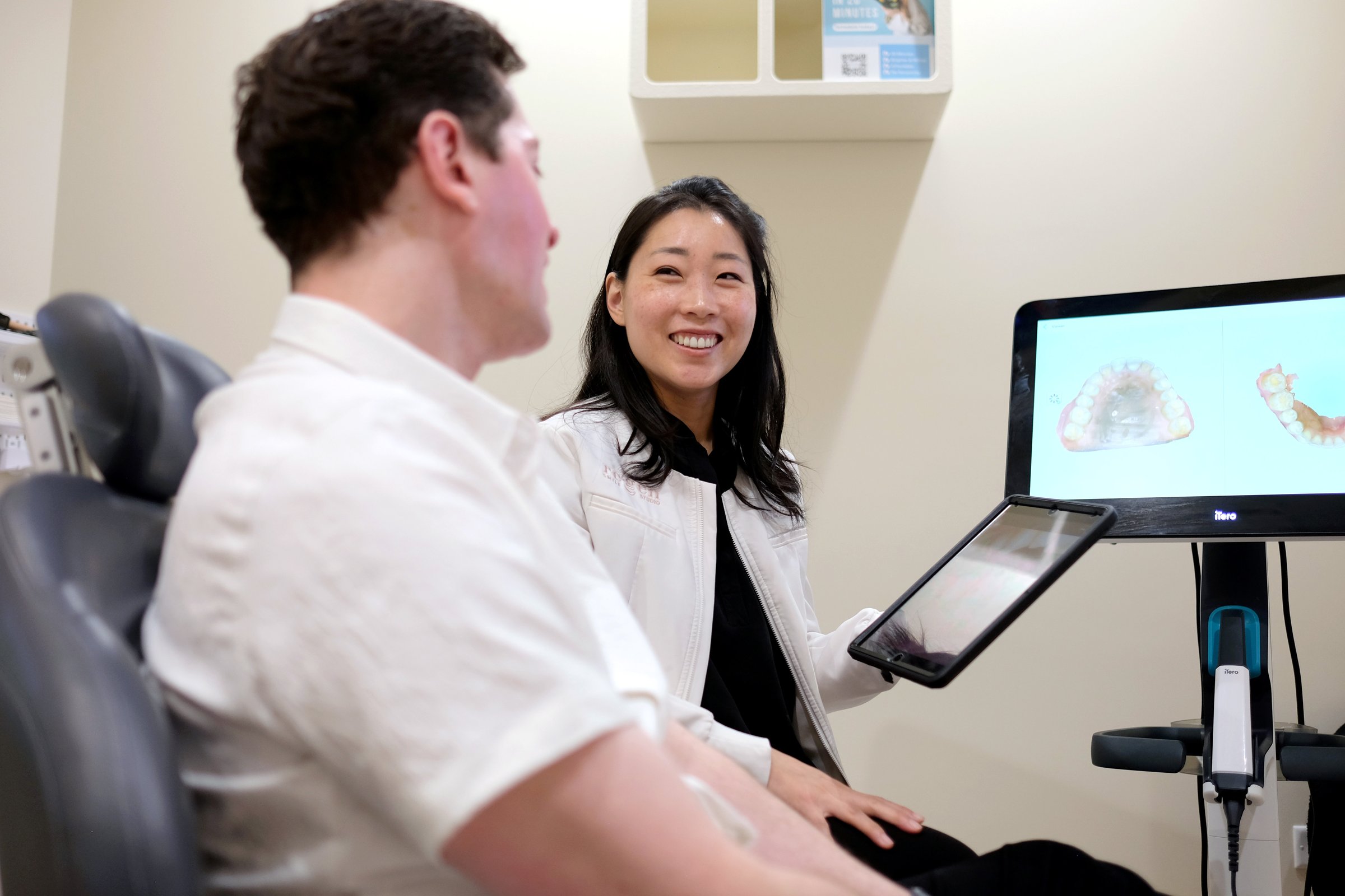 Dr. Erin Cho smiling beside a patient, his scan on the screen