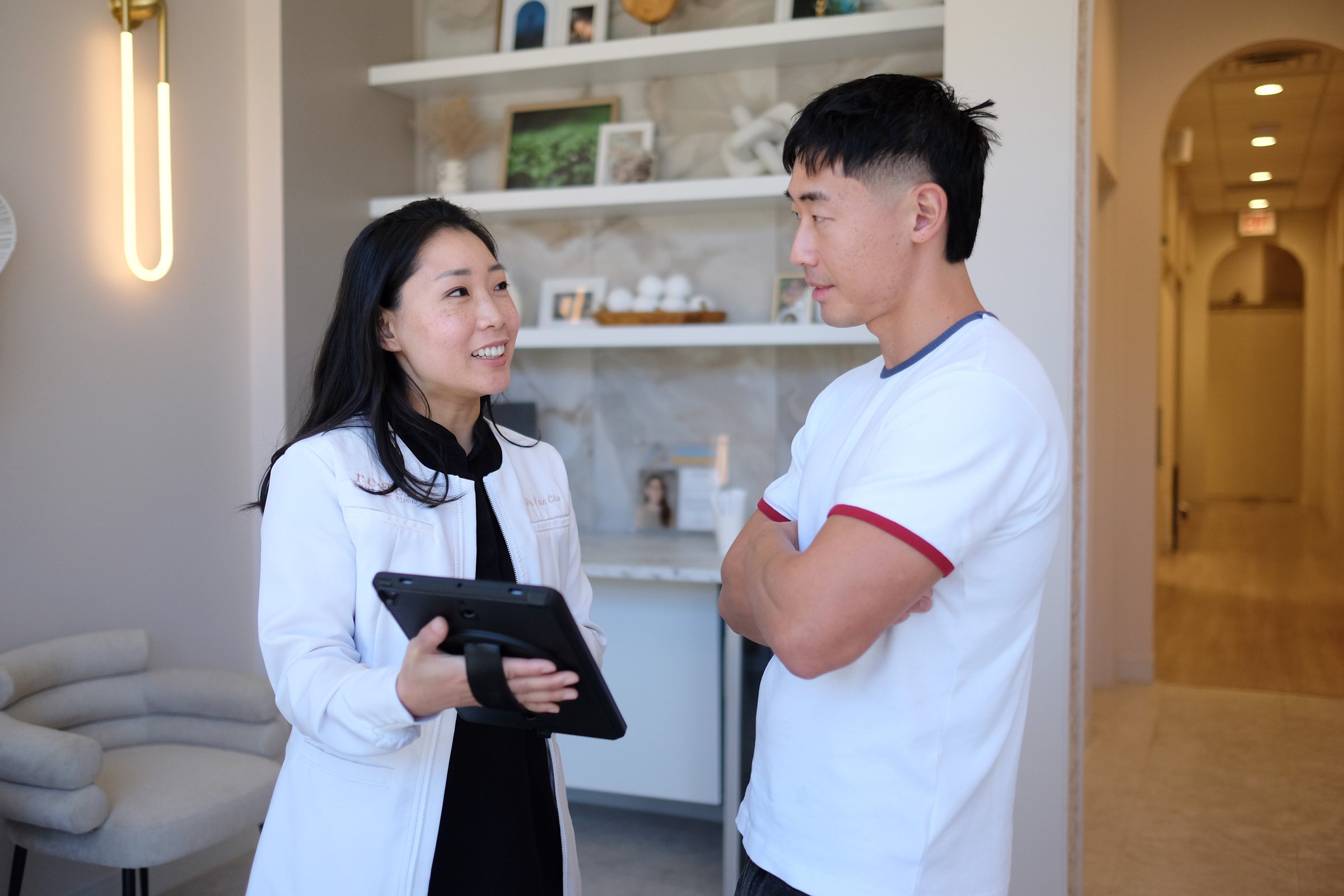 Dr. Erin Cho going over a treatment plan on a tablet with a patient